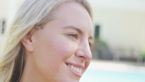 Close-up-of-smiling-caucasian-woman-walking-outdoors-by-pool