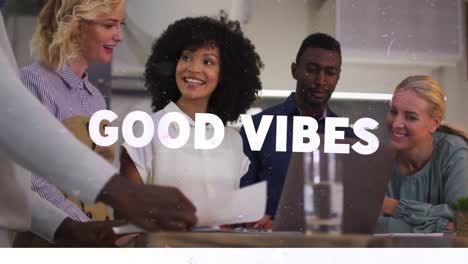 Animation-of-good-vibes-text-over-smiling-diverse-business-people-using-laptop