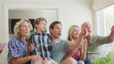 Glückliche-Kaukasische-Familie,-Die-Fernsieht-Und-Im-Wohnzimmer-Unterstützt
