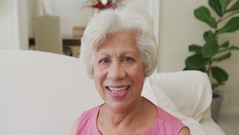 Retrato-De-Una-Mujer-Birracial-Senior-Sonriente-Mirando-La-Cámara-En-La-Sala-De-Estar