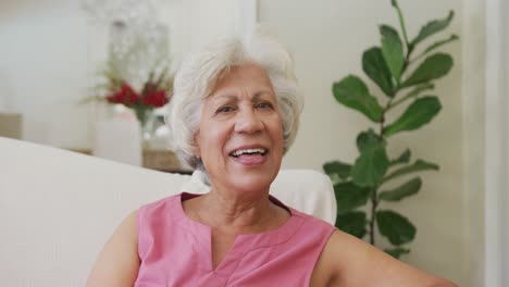Retrato-De-Una-Mujer-Birracial-Senior-Sonriente-Mirando-La-Cámara-En-La-Sala-De-Estar