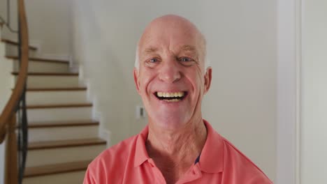 Portrait-of-smiling-senior-caucasian-man-looking-at-camera-at-home