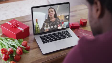 Happy-caucasian-woman-with-wine-making-valentine's-day-video-call-on-laptop