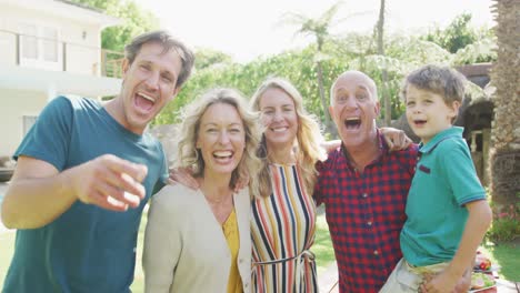 Portrait-of-happy-caucasian-family-embracing-and-looking-at-camera-in-garden