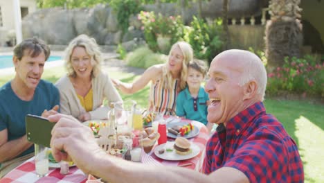 Happy-caucasian-family-having-dinner-and-taking-selfie-in-garden