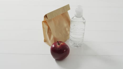 Animation-of-paper-lunch-bag-an-fruits-on-blue-background