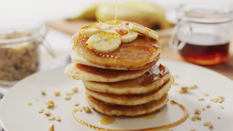 Video-of-pancakes-on-plate-seen-from-above-on-wooden-background