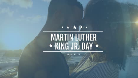 Animation-of-martin-luther-king-day-text-over-african-american-couple-at-beach