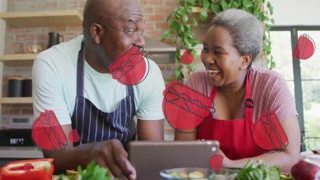 Multiple-burger-icons-against-african-american-senior-couple-using-digital-tablet-in-the-kitchen