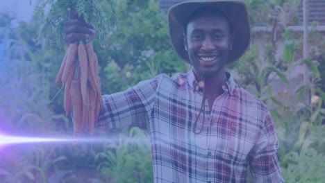 Video-of-blue-lights-over-smiling-african-american-man-holding-carrots