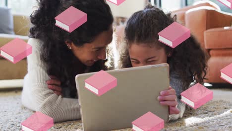 Pink-book-icons-in-seamless-motion-against-caucasian-mother-and-daughter-using-digital-tablet