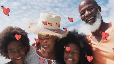 Animation-of-hearts-over-smiling-african-american-family-smiling-and-embracing