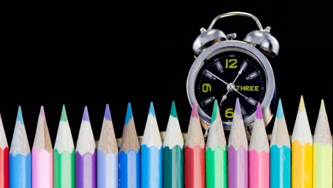 Animation-of-pencils-over-clock-moving-on-black-background