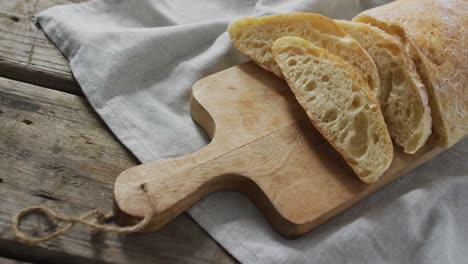 Video-of-bread-on-chopping-wooden-board-on-wooden-worktop