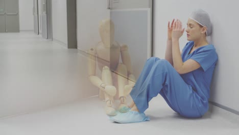 Animation-of-caucasian-female-nurse-sitting-on-floor-over-sitting-wooden-puppet