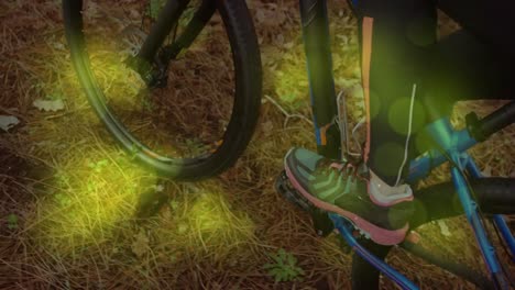 Animation-of-shapes-moving-over-caucasian-man-cycling-in-forest