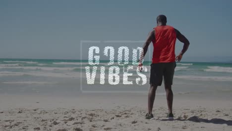 Animation-of-good-vibes-text-with-african-american-man-stretching-at-beach