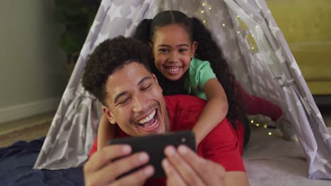 Glücklicher-Gemischtrassiger-Vater-Und-Tochter,-Die-Gemeinsam-Smartphone-Nutzen