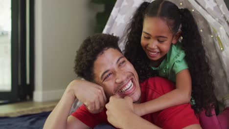 Happy-biracial-father-and-daughter-embracing-and-smiling