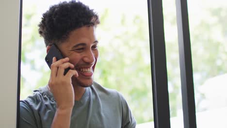 Happy-biracial-man-talking-on-smartphone-and-smiling