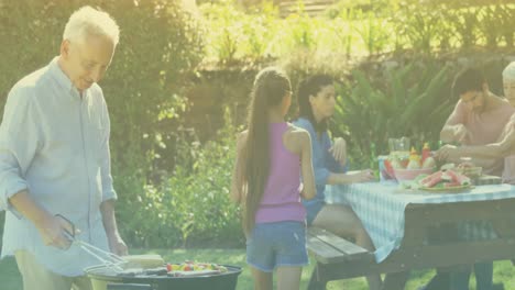 Animation-of-smiling-caucasian-family-having-barbecue