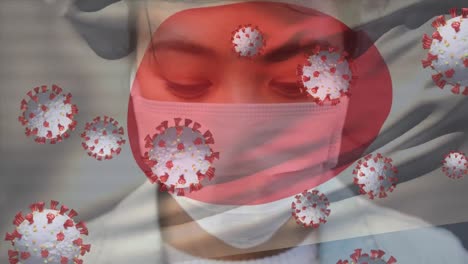 Animation-of-virus-cells-and-flag-of-japan-over-asian-woman-wearing-face-mask