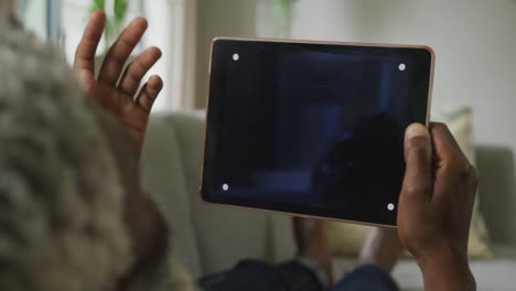 Video-Eines-Afroamerikanischen-älteren-Mannes,-Der-Ein-Tablet-Mit-Schwarzem-Bildschirm-Verwendet