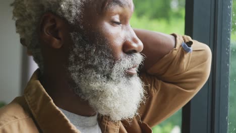 Video-Eines-Traurigen-Afroamerikanischen-älteren-Mannes,-Der-Aus-Dem-Fenster-Schaut