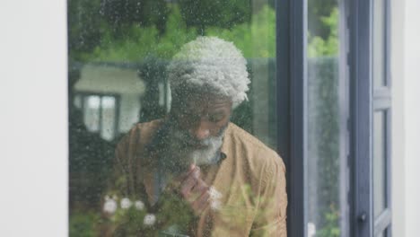 Video-Eines-Traurigen-Afroamerikanischen-älteren-Mannes,-Der-Aus-Dem-Fenster-Schaut