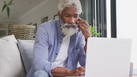 Video-Eines-Afroamerikanischen-älteren-Mannes,-Der-Smartphone-Und-Laptop-Benutzt