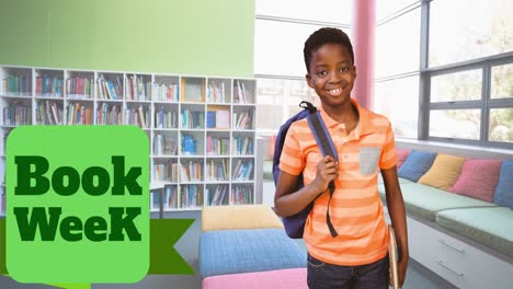 Animation-of-book-week-text-over-smiling-african-american-schoolboy-in-library