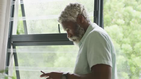 Video-of-african-american-senior-man-using-smartphone