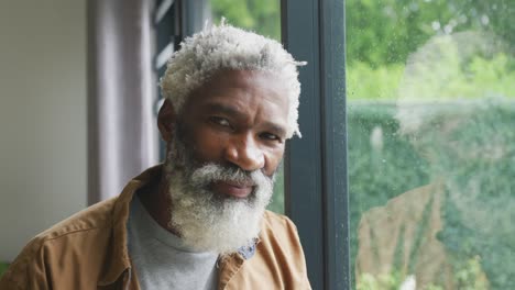 Video-Eines-Glücklichen-Afroamerikanischen-älteren-Mannes,-Der-Aus-Dem-Fenster-Schaut