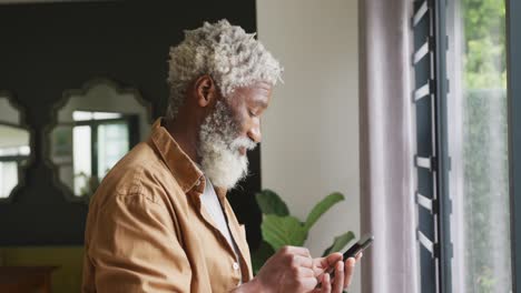 Video-of-african-american-senior-man-using-smartphone