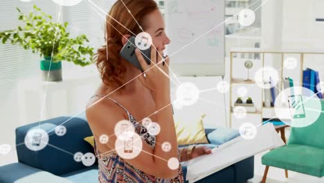 Animation-of-network-of-connections-with-icons-over-caucasian-businesswoman-using-smartphone
