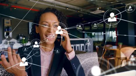 Animation-of-network-of-connections-with-people-icons-over-biracial-businesswoman-using-smartphone