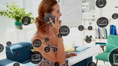 Animation-of-network-of-connections-with-icons-over-caucasian-businesswoman-using-smartphone