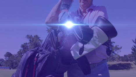 Animation-of-light-trails-over-senior-caucasian-man-playing-golf-on-golf-course