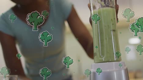 Animation-of-broccoli-over-african-american-woman-preparing-smoothie-in-kitchen