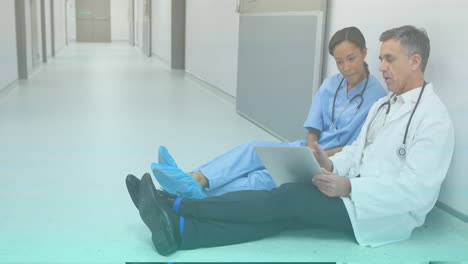 Animation-of-caucasian-male-doctor-with-tablet-talking-with-nurse-on-floor