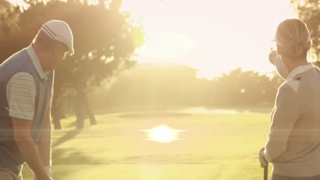 Animation-of-light-trails-ver-senior-caucasian-couple-playing-golf-on-golf-course