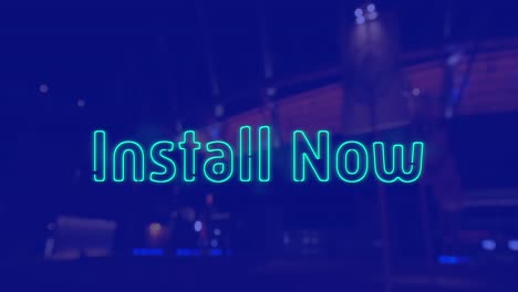 Animation-of-install-now-text-over-cityscape-at-night-on-blue-background