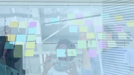 Animation-of-data-processing-over-diverse-group-of-business-people-taking-notes-on-glass-wall