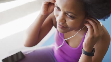 Happy-african-american-wearing-sportswear-and-earphones,-exercising