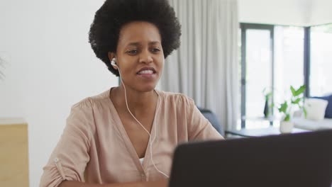 Glückliche-Afroamerikanische-Frau,-Die-Am-Tisch-Sitzt-Und-Einen-Laptop-Benutzt