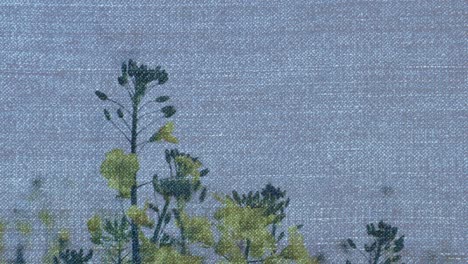 Animation-of-denim-over-moving-flowers-and-grass