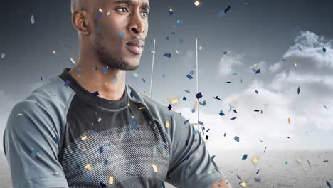 Animation-of-confetti-over-african-american-male-rugby-player-with-ball-at-stadium