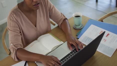 Feliz-Mujer-Afroamericana-Sentada-En-La-Mesa-Usando-Una-Computadora-Portátil