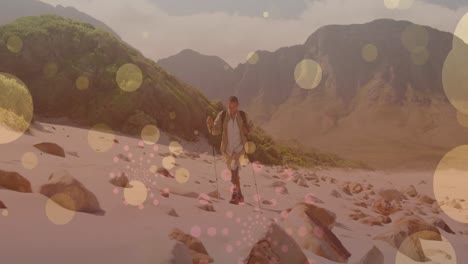Animation-of-light-spots-over-disabled-biracial-man-walking-in-mountains