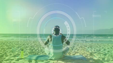 Animation-of-scope-scanning-over-african-american-man-meditating-at-beach